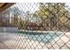 View through chainlink fence of tennis courts and wooded area at 4837 Mystere Cir, Lilburn, GA 30047