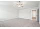 Bedroom with neutral walls, carpet, ceiling fan, and a hallway leading to other rooms at 2027 Wyndham Pl, Conyers, GA 30013