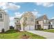 Inviting home with a two-car garage, modern facade, complemented by a green lawn and young tree at 2027 Wyndham Pl, Conyers, GA 30013