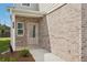 Close-up of the front entry with attractive brickwork, and a charming front door at 2027 Wyndham Pl, Conyers, GA 30013