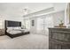 Elegant Primary bedroom with a tray ceiling, a lavish headboard, and natural light streaming through the windows at 2029 Wyndham Pl, Conyers, GA 30013