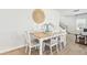 Dining area features a wood table with white chairs, wood floors, and neutral wall decor at 2029 Wyndham Pl, Conyers, GA 30013