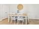 Dining room features a wood table with white chairs, wood floors, and neutral wall decor at 2029 Wyndham Pl, Conyers, GA 30013