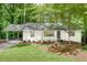 Charming white home featuring a convenient carport and a well-manicured front yard, surrounded by lush greenery at , Atlanta, GA 30329