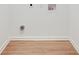 A minimalist laundry room with light wood flooring and white walls at , Atlanta, GA 30329