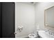 A well-lit half bathroom features a modern toilet, sink, mirror, and black door at 1120 Sunny Lake Dr, Lawrenceville, GA 30043