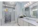 Bright bathroom featuring double vanity with white marble counters, chandelier, and tile walk-in shower at 2109 Rugby Ave, Atlanta, GA 30337