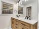 Modern bathroom with double vanity, wood cabinets, updated lighting, and a large mirror at 2490 Brookcliff Ne Way, Atlanta, GA 30345