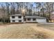 Charming home boasts a freshly painted white exterior, complemented by black trim and a lush, green backdrop at 2490 Brookcliff Ne Way, Atlanta, GA 30345