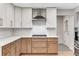 Kitchen with stainless steel gas range, hood, two-tone cabinets, quartz countertops, and white subway tile backsplash at 2490 Brookcliff Ne Way, Atlanta, GA 30345