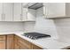 Close up on the kitchen gas range with white countertops, subway tiles, and two-tone modern cabinets at 2490 Brookcliff Ne Way, Atlanta, GA 30345