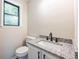 Bathroom vanity with a granite countertop, dark hardware, and window at 557 Old Friar Tuck Ln, Stone Mountain, GA 30087