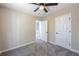 Carpeted bedroom with a ceiling fan, and doorways to other rooms at 557 Old Friar Tuck Ln, Stone Mountain, GA 30087