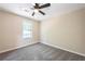 Bedroom with neutral walls, carpet flooring, ceiling fan, and window at 557 Old Friar Tuck Ln, Stone Mountain, GA 30087