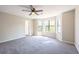 Bright and airy bedroom with carpeting, fan, and three large windows at 557 Old Friar Tuck Ln, Stone Mountain, GA 30087