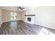 Spacious living room featuring wood-look floors, a ceiling fan, and a white-painted fireplace at 557 Old Friar Tuck Ln, Stone Mountain, GA 30087