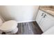 Powder room with stylish wood-look tile floor, granite countertop and modern toilet at 557 Old Friar Tuck Ln, Stone Mountain, GA 30087