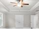Bedroom boasts trey ceiling, neutral walls, carpet, ceiling fan, and a double door closet at 2020 Manor Pointe Dr, Cumming, GA 30041