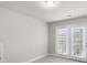 Bedroom offers neutral carpet, a ceiling light, and double doors to a private patio at 2020 Manor Pointe Dr, Cumming, GA 30041