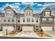 Street view of townhomes featuring neutral siding, stone accents, individual garages, and charming balconies under a partly cloudy sky at 2020 Manor Pointe Dr, Cumming, GA 30041
