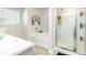 Bathroom featuring a shower with glass doors, a soaking tub, and natural light from window with blinds at 375 Milton Dr, Covington, GA 30016
