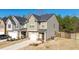 Exterior side view featuring a neutral-colored two-story home, complemented by a well-maintained lawn and a private driveway at 375 Milton Dr, Covington, GA 30016