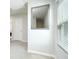Hallway with a mirror, window and white walls with light carpet and doors at 375 Milton Dr, Covington, GA 30016