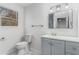 Bathroom featuring a window, toilet, single vanity sink, and a mirror that reflects the bedroom at 7155 Pineneedle Drive Sw, Covington, GA 30016