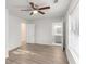 Bedroom featuring light-colored wood look floors, a ceiling fan, and a view into the ensuite bathroom at 7155 Pineneedle Drive Sw, Covington, GA 30016