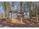 Charming home featuring a quaint front porch and stairs nestled within a wooded landscape at 7155 Pineneedle Drive Sw, Covington, GA 30016