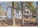 Charming home featuring a quaint front porch and stairs nestled within a wooded landscape at 7155 Pineneedle Drive Sw, Covington, GA 30016