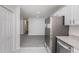 Spacious hallway leading to a well-equipped kitchen, stainless steel appliances, and white cabinetry at 7155 Pineneedle Drive Sw, Covington, GA 30016
