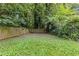 A spacious backyard, partially covered in grass and enclosed by a wooden fence and mature trees at 2825 3Rd Sw Ave, Atlanta, GA 30315