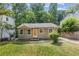 Charming single-story home featuring a well-maintained lawn, complemented by mature trees and an inviting orange front door at 2825 3Rd Sw Ave, Atlanta, GA 30315