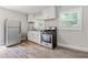 This light and airy kitchen boasts stainless steel appliances, clean white cabinets, and sleek hardwood flooring at 2825 3Rd Sw Ave, Atlanta, GA 30315