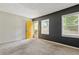 View of a carpeted living room showcasing a bright yellow entry door and natural light from the windows at 2825 3Rd Sw Ave, Atlanta, GA 30315