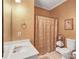 Cozy bathroom showcasing a single sink vanity, a toilet, and a shower with gold-toned curtain at 155 Matthew Way, Fayetteville, GA 30214
