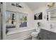 Bright bathroom with a window seat, gray vanity, toilet, and shower at 166 Erie Ave, Decatur, GA 30030