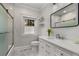 Bright bathroom with white vanity, marble floors, and shower with glass doors at 166 Erie Ave, Decatur, GA 30030