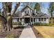 Classic two-story home with mature trees and manicured landscaping, creating a serene and inviting atmosphere at 166 Erie Ave, Decatur, GA 30030