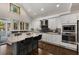 Kitchen featuring stainless steel appliances, white cabinets, island and granite countertops at 166 Erie Ave, Decatur, GA 30030