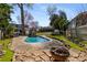 A luxurious pool is surrounded by stone patio, lush greenery, and a charming pool house, perfect for relaxation at 166 Erie Ave, Decatur, GA 30030