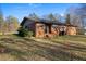 Exterior of the house with a brick facade, grassy yard and mature trees at 7427 Hollis Rd, Douglasville, GA 30135