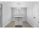 Eat-in kitchen featuring modern lighting and gray wood-look floors with a white granite island at 7427 Hollis Rd, Douglasville, GA 30135