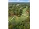 An aerial view showcases the home nestled within a lush, wooded landscape with a nearby golf course at 9570 Huntcliff Trce, Atlanta, GA 30350