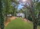 A spacious, well-manicured backyard featuring a patio, outdoor kitchen, and fire pit, surrounded by lush greenery at 9570 Huntcliff Trce, Atlanta, GA 30350