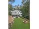 A spacious backyard featuring a patio, outdoor kitchen, and fire pit, surrounded by lush greenery at 9570 Huntcliff Trce, Atlanta, GA 30350