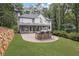 Spacious backyard with stone patio, outdoor seating, and well-maintained lawn at 9570 Huntcliff Trce, Atlanta, GA 30350