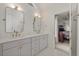Bathroom featuring double sinks, modern fixtures, and a doorway to bedroom at 9570 Huntcliff Trce, Atlanta, GA 30350