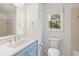 Cozy bathroom featuring a blue vanity, hexagon tile floor and bright window view at 9570 Huntcliff Trce, Atlanta, GA 30350